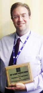 Director of Software Development, Casey Kennedy, holds the NACM Top 10 Websites of 2015 Plaque