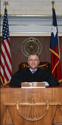 Chief Justice Tom Gray with US and Texas flags and Tenth Court of Appeals seal